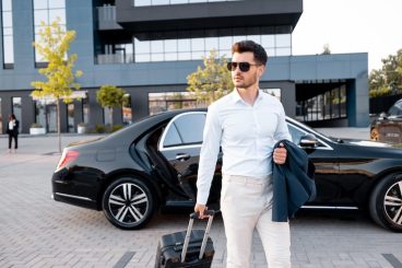 elegant-businessman-walks-with-suitcase-outdoors_506452-22448